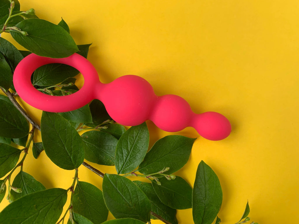 Sex shop assortment. Pink butt plug on a yellow background. Useful for sex shop, adults. Subreddit icon for reddit group r/sexbloggerposts