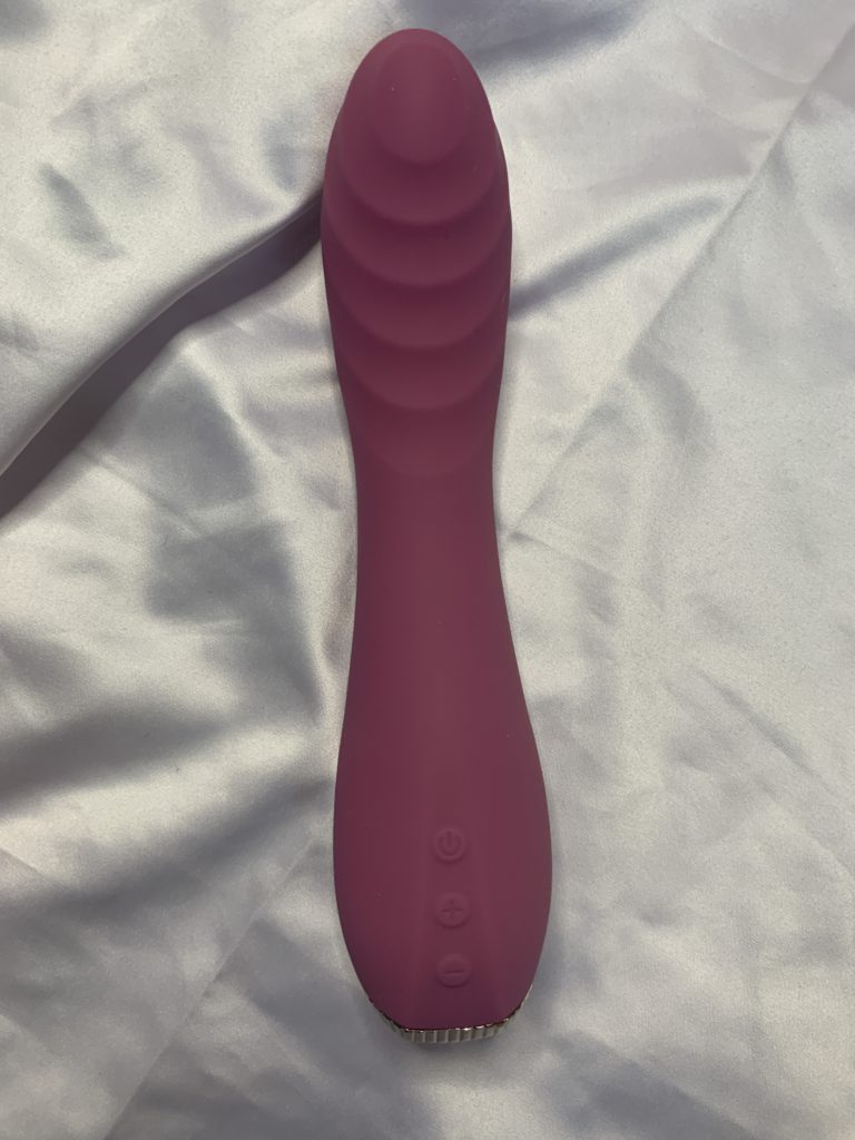 Cal Exotics Uncorked Pinot is a g-spot vibrator sex toy. It sits on white satin. 