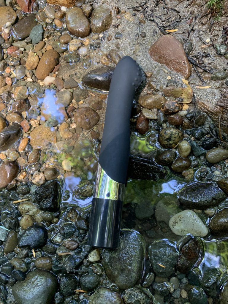 The Nu Sensuelle Pearl G-Spot vibrator rests in a flowing stream. You can see the nub that strokes the g-spot in its profile