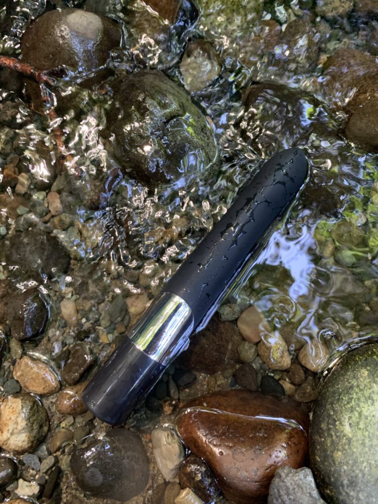 The Sensuelle Pearl g spot vibrator is upside down in a stream. It's a gorgeous, keep black vibrator that ironically isn't waterproof. 