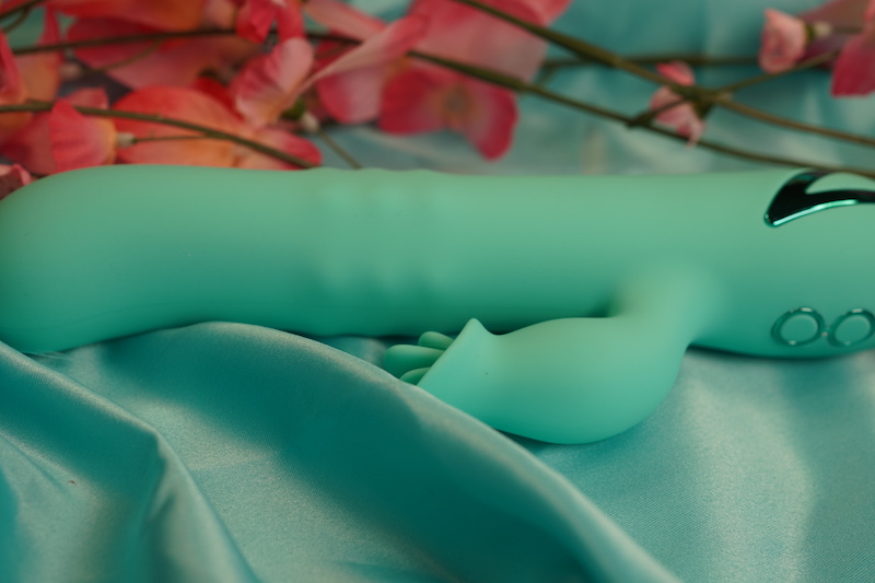 The Bel Air Bombshell lays on matching teal fabric with flowers in the background. 
